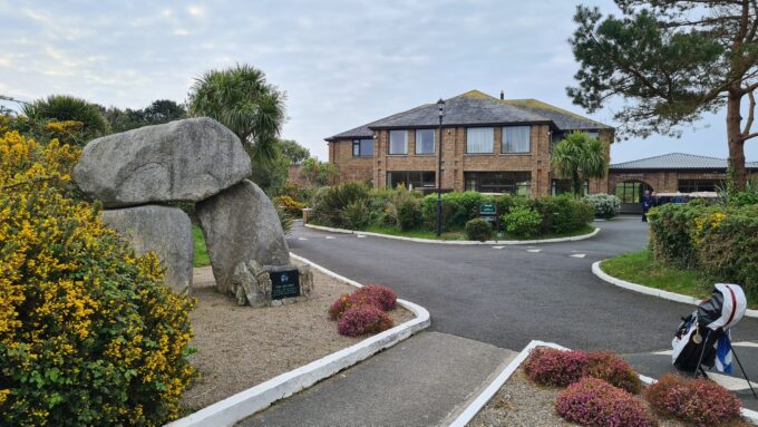 Strax utanför parkeringen välkomnar dolmen i klubbhuset The European Club dig